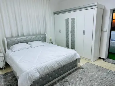a bedroom with a large bed and a large closet at شقة مفروشة واسعة وهادئة in Umm Juraysāt