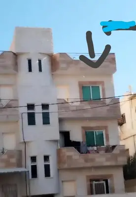 a building with a pair of shoes hanging from wires at البيت المُريح in Aqaba