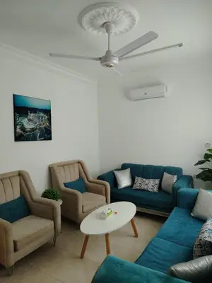 a living room with blue couches and a table at البيت المُريح in Aqaba