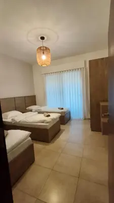 a bedroom with two beds and a chandelier at Al-Raha Luxury apartment in Aqaba