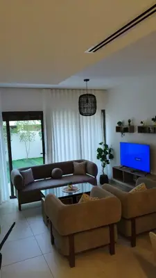 a living room with two couches and a tv at Al-Raha Luxury apartment in Aqaba