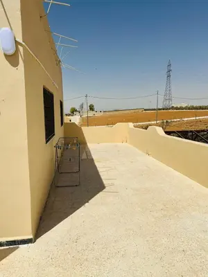 a building with a gate on the side of it at شقة واسعة وهادئة in Umm Juraysāt