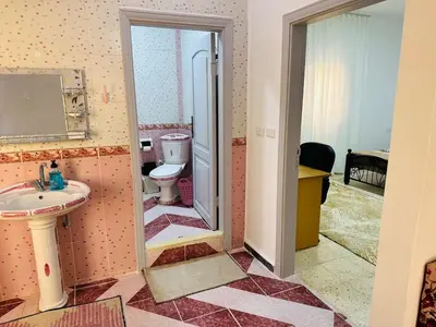 a bathroom with a toilet and a sink at شقة واسعة وهادئة in Umm Juraysāt
