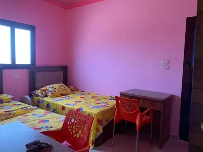 a bedroom with two beds and a table and chairs at Jorh BB in Amman