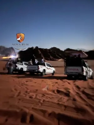 two trucks in the desert with a load on the back at Nova Rum Luxury Camp in Disah