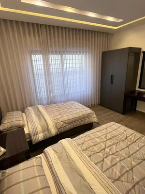a hotel room with two beds and a window at Luxurious 2 bedroom furnished apartment in Abdoun in Amman