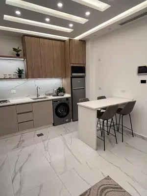 a kitchen with a sink and a table and chairs at Luxurious 2 bedroom furnished apartment in Abdoun in Amman