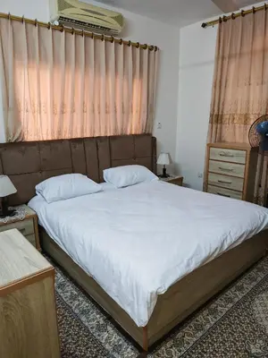a bedroom with a large bed with white sheets at Luxury Apartments in Aqaba
