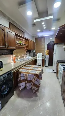 a large kitchen with a table in the middle at Luxury Apartments in Aqaba