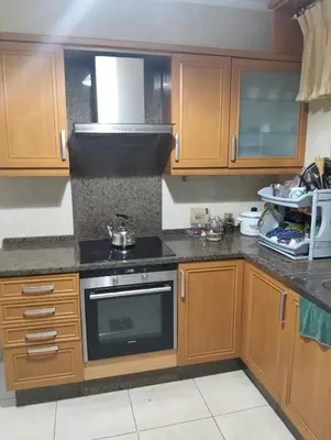 a kitchen with wooden cabinets and a stove top oven at عمان in Amman