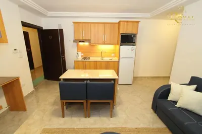 a kitchen and a living room with a table and a couch at Ammoun Luxury Apartments 1 in Amman