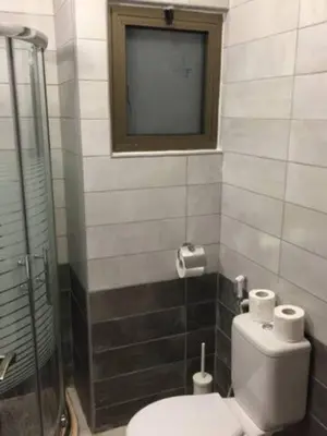 a bathroom with a toilet and a window on the wall at Ammoun Luxury Apartments 1 in Amman