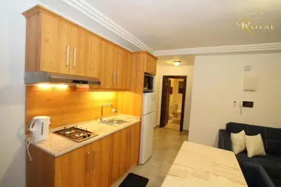 a kitchen with wooden cabinets and a sink and a stove at Ammoun Luxury Apartments 1 in Amman
