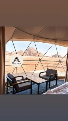 a tent with two benches and a table and a view of the desert at Ramses luxury rum camp in Wadi Rum