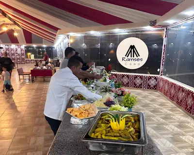 a chef preparing food at a buffet in a restaurant at Ramses luxury rum camp in Wadi Rum
