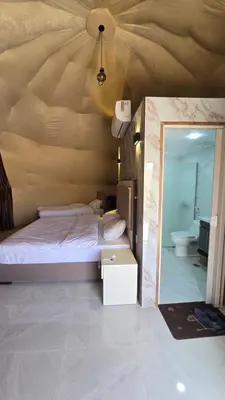 a bedroom with a bed and a mirror at Fahd Camp Wadi Rum in Wadi Rum