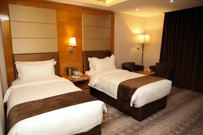 a hotel room with two beds and a desk at Petra Breeze in Wadi Musa