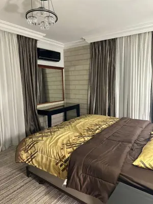 a bedroom with a bed and a mirror and a table at Super deluxe apartment in Irbid