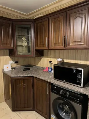 a kitchen with a washing machine and a microwave at Super deluxe apartment in Irbid