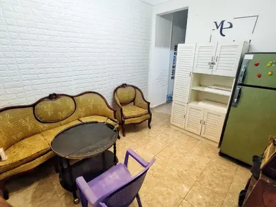 a room with a table and chairs and a refrigerator at Hi motel in Al ‘Iş