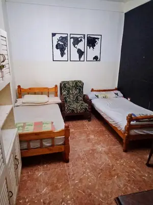 a room with two beds and a chair in it at Hi motel in Al ‘Iş