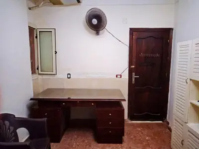 a room with a wooden desk and a door at Hi motel in Al ‘Iş
