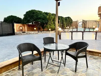 a table and chairs and an umbrella on a patio at مزرعة وشاليه ادم