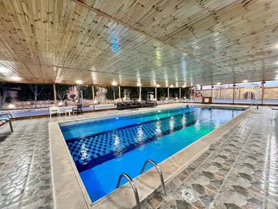 a large swimming pool with blue water in a building at مزرعة وشاليه ادم