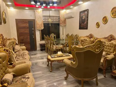 a room with chairs and a table and a dining room at No Stars in ‘Urjān al Gharbīyah