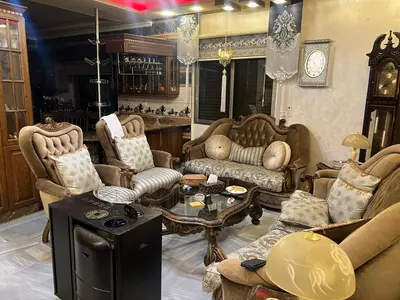 a living room with couches and chairs and a table at No Stars in ‘Urjān al Gharbīyah