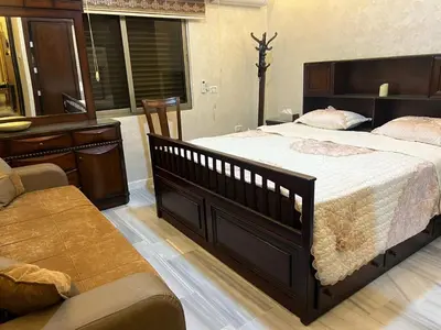 a bedroom with a large bed and a couch at No Stars in ‘Urjān al Gharbīyah