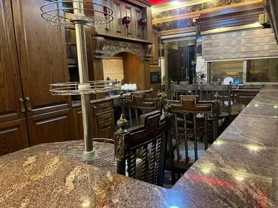 a bar in a restaurant with a counter and chairs at No Stars in ‘Urjān al Gharbīyah