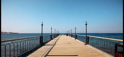 a wooden pier with lights on the water at Two Bed rooms apartment in Talabay Aqaba Jordan in Aqaba