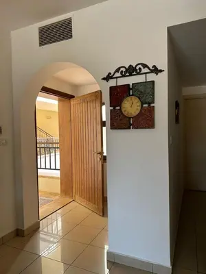 a hallway with a clock on the wall and a door at Two Bed rooms apartment in Talabay Aqaba Jordan in Aqaba