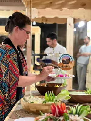 a woman standing in a kitchen preparing food at MARS GATE lUXURY BUBBLE CAMP in Wadi Rum