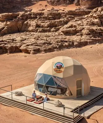 two people sitting in a dome tent in the desert at MARS GATE lUXURY BUBBLE CAMP in Wadi Rum