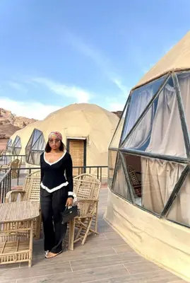 a woman standing in front of some tents at MARS GATE lUXURY BUBBLE CAMP in Wadi Rum