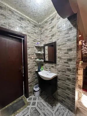 a bathroom with a sink and a stone wall at Petra Hospitality in Wadi Musa