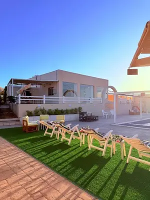 a group of wooden tables and chairs on a lawn at Milano villa & farm in Balīlā