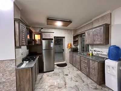 a kitchen with wooden cabinets and a stainless steel refrigerator at panorama tal elroman chalet in Tal‘at ar Ruzz