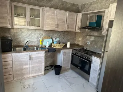 a kitchen with wooden cabinets and a sink and a stove at New Rooftop 3 bedroom furnished apartment- Super deluxe in Amman