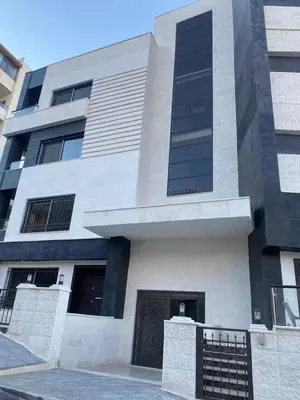 a large white building with a gate in front of it at New Rooftop 3 bedroom furnished apartment- Super deluxe in Amman