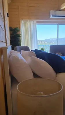 a couch with pillows on it in a room with a window at Akwakh Alkhair in Ajloun