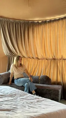 a woman sitting on a couch next to a bed at Rum Rhal Luxury Camp in Aqaba