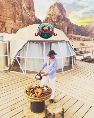 a man standing in front of a tent at WADI RUM EUROPE lUXURY CAMP in Wadi Rum