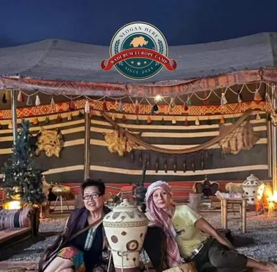 two people sitting in front of a tent with a vase at WADI RUM EUROPE lUXURY CAMP in Wadi Rum
