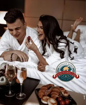 a man and a woman laying in bed with a plate of food at WADI RUM EUROPE lUXURY CAMP in Wadi Rum
