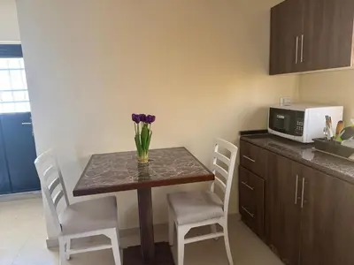 a kitchen with a table with a vase of flowers on it at Casa de petra in Wadi Musa