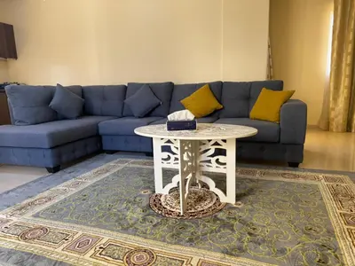 a living room with a blue couch and a table at Casa de petra in Wadi Musa