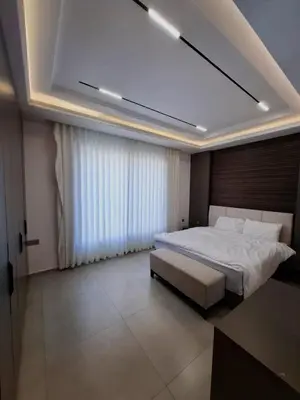 a bedroom with a large bed and a large window at The Boulevard Residences in Amman